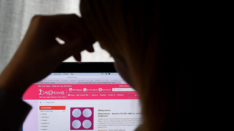 Una mujer mira una píldora abortiva (RU-486) mostrada en una computadora en Arlington, Virginia, el 8 de mayo de 2020. (Olivier Douliery/AFP vía Getty Images)