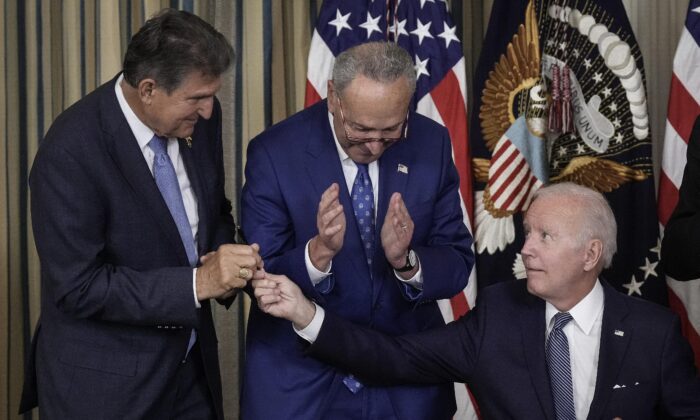 El presidente Joe Biden entrega al senador Joe Manchin (D-W.Va.) el bolígrafo que usó para promulgar la Ley de Reducción de la Inflación en la Casa Blanca, el 16 de agosto de 2022. (Drew Angerer/Getty Images)