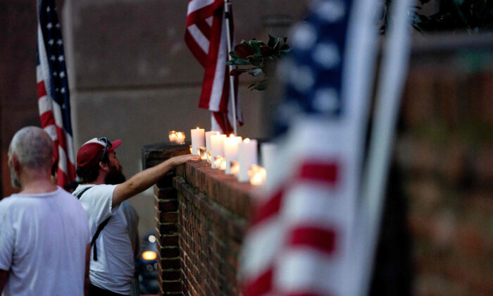 Los manifestantes del grupo "Look Ahead America" encienden velas frente al Centro Correccional de DC durante una manifestación, el 30 de agosto de 2022, para las personas que han sido encarceladas por su participación en la irrupción del 6 de enero en el Capitolio de EE.UU. (STEFANI REYNOLDS/AFP vía Getty Images)
