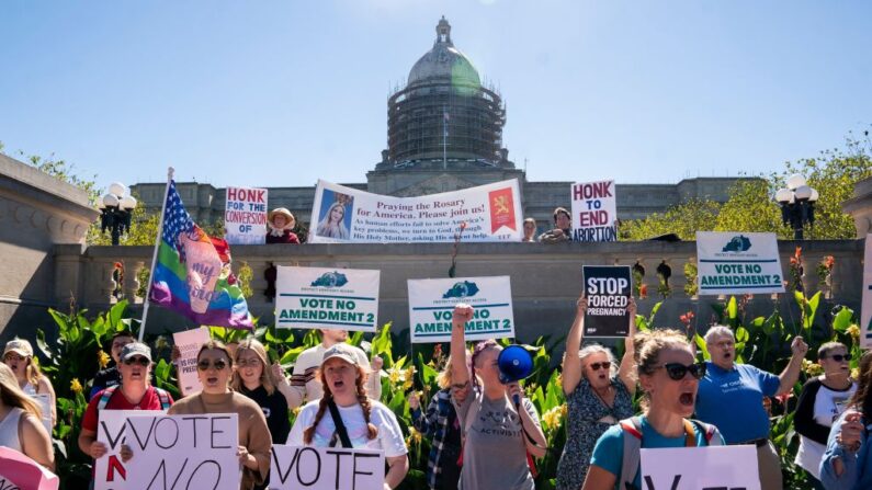 Contramanifestantes sostienen pancartas frente a una concentración que anima a los votantes a votar sí a la Enmienda 2, que añadiría una prohibición permanente del aborto a la Constitución del estado de Kentucky, en las escaleras del Capitolio del Estado de Kentucky en Frankfort, Kentucky, el 1 de octubre de 2022. (STEFANI REYNOLDS/AFP vía Getty Images)