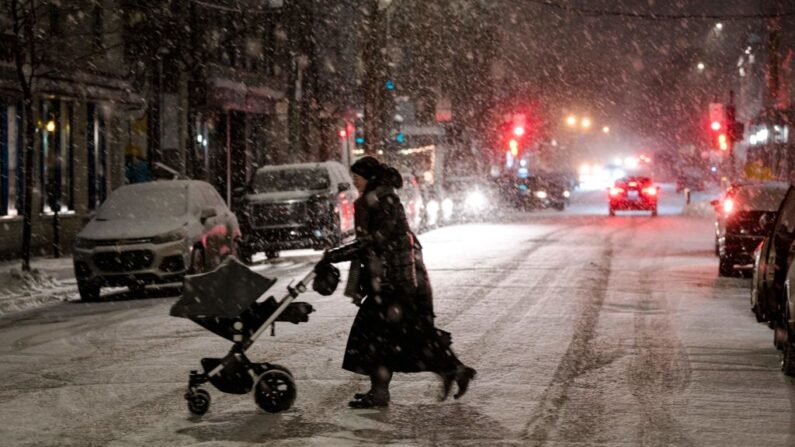 Una persona cruza una calle en Mile End, un barrio de Montreal, Quebec, Canadá, mientras cae la nieve el 22 de diciembre de 2022. (Andrej Ivanov/AFP vía Getty Images)