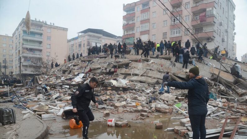 Varias personas buscan supervivientes entre los escombros en Diyarbakir, el 6 de febrero de 2023, tras el terremoto de magnitud 7,8 que sacudió el sureste del país. (ILYAS AKENGIN/AFP vía Getty Images)