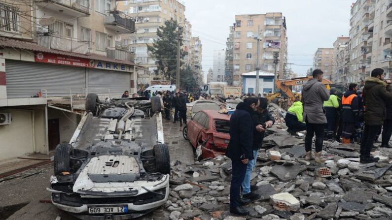 Varias personas buscan supervivientes entre los escombros en Diyarbakir, el 6 de febrero de 2023, tras el terremoto de magnitud 7,8 que sacudió el sureste del país. (ILYAS AKENGIN/AFP vía Getty Images)