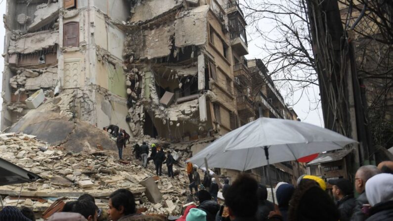 Los equipos de rescate buscan supervivientes bajo los escombros de un edificio derrumbado tras un terremoto en Alepo, ciudad del norte de Siria controlada por el régimen, el 6 de febrero de 2023.  (AFP vía Getty Images)