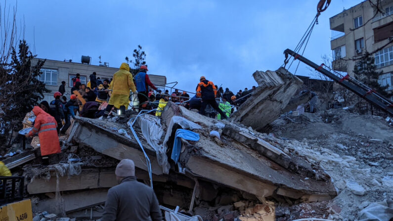 Rescatistas y voluntarios buscan supervivientes entre los escombros de un edificio derrumbado, en Sanliurfa, Turquía, el 6 de febrero de 2023, tras el terremoto de magnitud 7.8 que sacudió el sureste del país. (Remi Banet/AFP vía Getty Images)