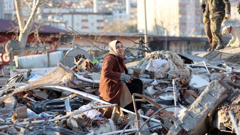 Una mujer sentada sobre los escombros de un edificio destruido en Kahramanmaras, sur de Turquía, un día después de que un terremoto de magnitud 7.8 sacudiera el sureste del país, el 7 de febrero de 2023. (Adem Altan/AFP vía Getty Images)