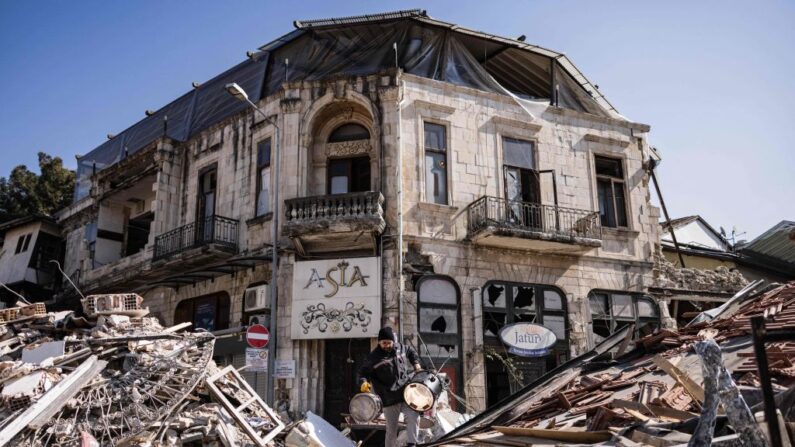 Un hombre saca instrumentos musicales de su tienda dañada en Antakya (Turquía) el 18 de febrero de 2023. (Sameer Al-Doumy/AFP vía Getty Images)