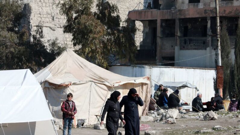 Sirios desplazados por el terremoto que asoló Turquía y Siria a principios de mes caminan por un campamento improvisado en el barrio de Bustan al-Basha, en la ciudad septentrional de Alepo, en manos del gobierno, el 20 de febrero de 2023. (Louai Beshara/AFP vía Getty Images)