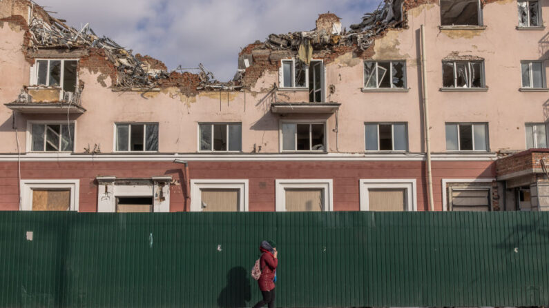 Una mujer pasa junto a un edificio de hotel dañado durante los ataques rusos el 22 de febrero de 2023 en Chernihiv, Ucrania. (Roman Pilipey/Getty Images)