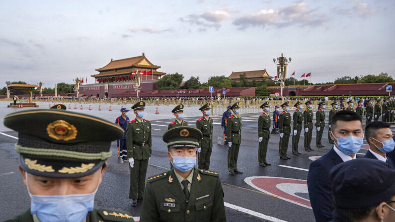 Oficiales de policía y seguridad bloquean el paso mientras realizan el control de multitudes tras una ceremonia oficial de izado de bandera para conmemorar el Día Nacional junto a la Plaza de Tiananmen y la Ciudad Prohibida, en Beijing, el 1 de octubre de 2021. (Kevin Frayer/Getty Images)