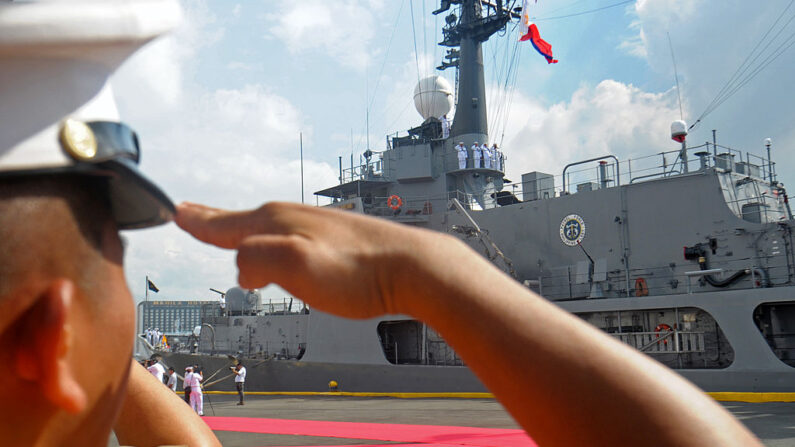Un soldado de la marina filipina saluda mientras se iza la bandera nacional en el recién adquirido cúter de clase Hamilton Gregorio del Pilar durante su ceremonia de entrega en Manila el 14 de diciembre de 2011. La ceremonia fue presidida por el presidente filipino, Benigno Aquino, quien, en un discurso pronunciado el 23 de agosto de 2011, prometió reforzar la defensa militar de su país en el Mar de China Meridional.  (Ted Aljibe/AFP via Getty Images)