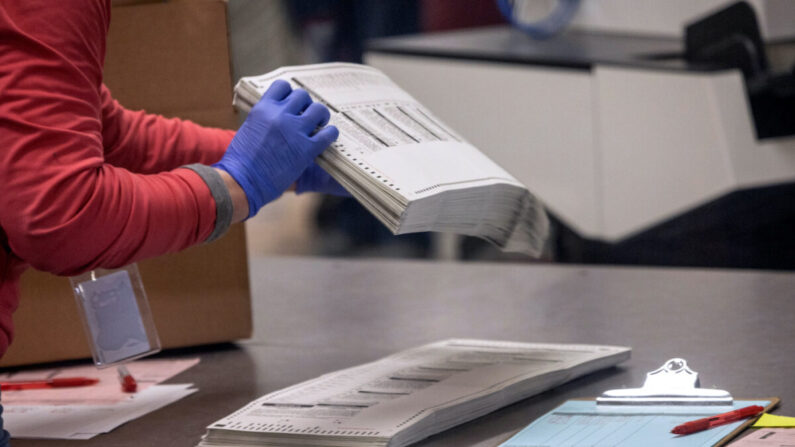 Un trabajador electoral clasifica papeletas en una foto de archivo. (John Moore/Getty Images)
