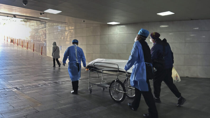 Trabajadores del hospital y un familiar sacan un cadáver en camilla de la concurrida sala de urgencias de un hospital de Beijing, China, el 2 de enero de 2023. (Getty Images)

