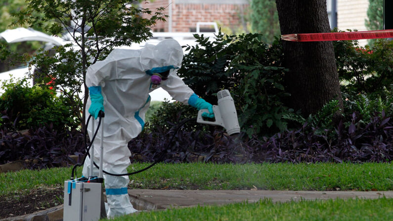 Un hombre en un traje para materiales peligrosos desinfecta en Dallas, Texas, 12 de octubre de 2014. (Crédito de Mike Stone/Getty Images)