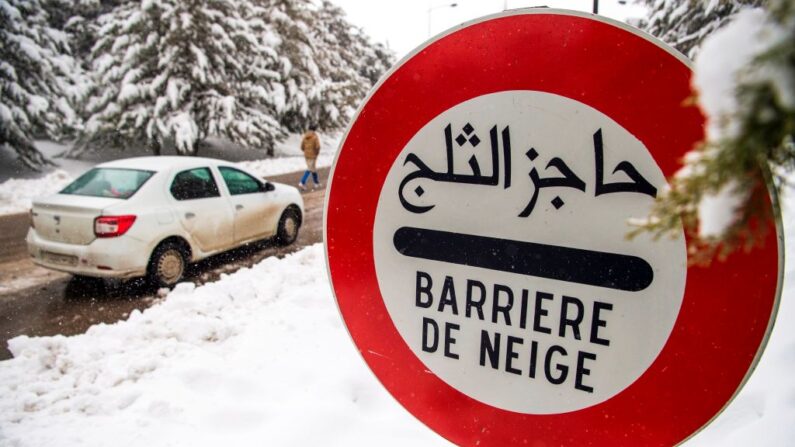 Una señal advierte a los conductores de un barrera de nieve en el lado de la carretera en la montañosa ciudad marroquí de Ifrane el 21 de enero de 2017. (FADEL SENNA/AFP via Getty Images)