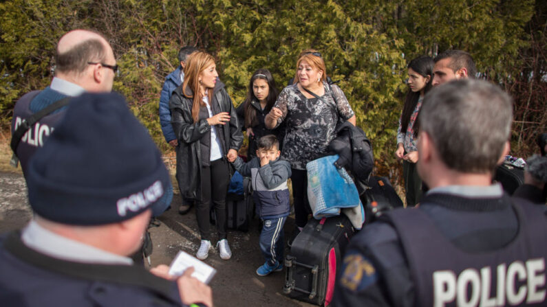 Una familia numerosa de 8 personas procedentes de Colombia habla con agentes de la Real Policía Montada de Canadá tras cruzar ilegalmente la frontera entre Estados Unidos y Canadá cerca de Hemmingford Quebec, 25 de febrero de 2017. (GEOFF ROBINS/AFP via Getty Images)