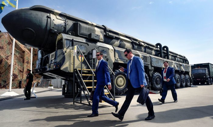 Especialistas militares pasan junto a un misil balístico intercontinental (ICBM) ruso Topol, en el campo de exposición del parque Kubinka Patriot, en las afueras de Moscú, el 22 de agosto de 2017. (Alexander Nemenov/AFP/Getty Images)
