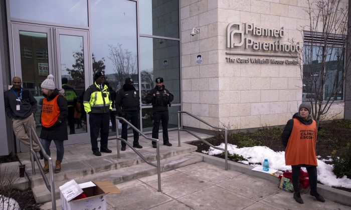 Agentes de policía y escoltas de la clínica se paran afuera de Planned Parenthood of Metropolitan Washington durante una vigilia de protesta en Washington el 17 de enero de 2019. (Zach Gibson/Getty Images)