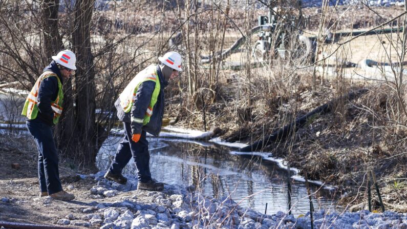 Trabajadores usan barreras y material absorbente para filtrar el agua en un arroyo de East Palestine City Park mientras continúa la limpieza después del descarrilamiento de un tren de carga de Norfolk Southern, en East Palestine, Ohio, el 18 de febrero de 2023. (EFE/EPA/Tannen Maury)