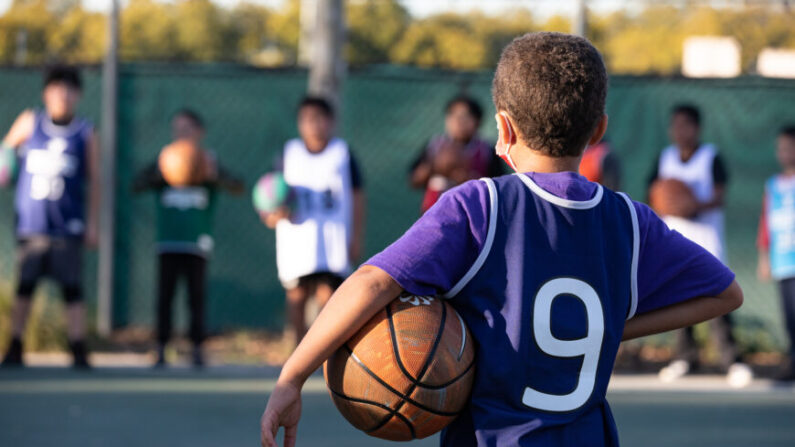Unos niños participan en una sesión de entrenamiento de baloncesto de una hora de duración organizada por la YMCA del condado de Orange en Fullerton, California, el 1 de febrero de 2023. (John Fredricks/The Epoch Times)