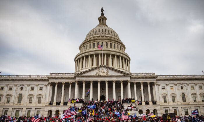 Un gran grupo de manifestantes se para en los escalones este del Capitolio de EE. UU. tras irrumpir en sus instalaciones en Washington, el 6 de enero de 2021. (Jon Cherry/Getty Images)