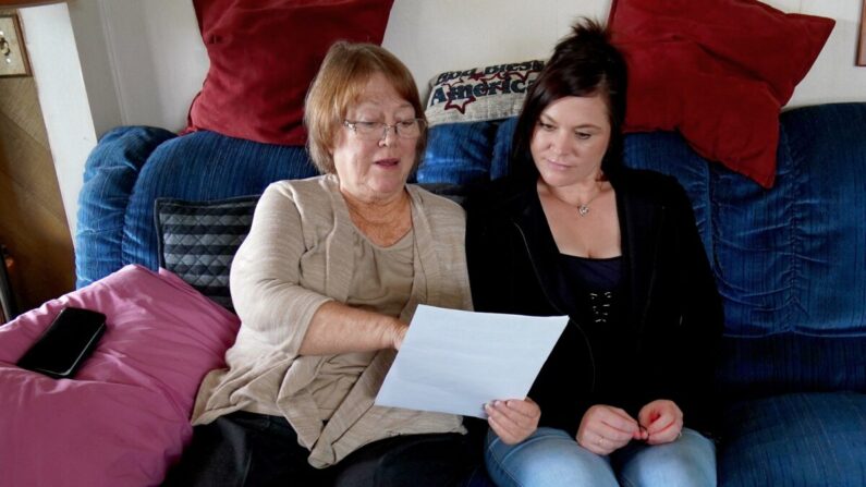 Linda Garinger (izq.), enferma renal terminal, y su hija Emily Lewis leen la carta de un hospital que deniega a Garinger una operación de trasplante de riñón por no recibir la vacuna contra el COVID-19. (Allan Stein/The Epoch Times)