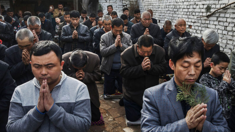 Fieles católicos chinos se arrodillan y rezan durante la misa del Domingo de Ramos durante la Semana Santa de Pascua en una iglesia "clandestina" o "no oficial" cerca de Shijiazhuang, provincia de Hebei, China, el 9 de abril de 2017. (Kevin Frayer/Getty Images)
