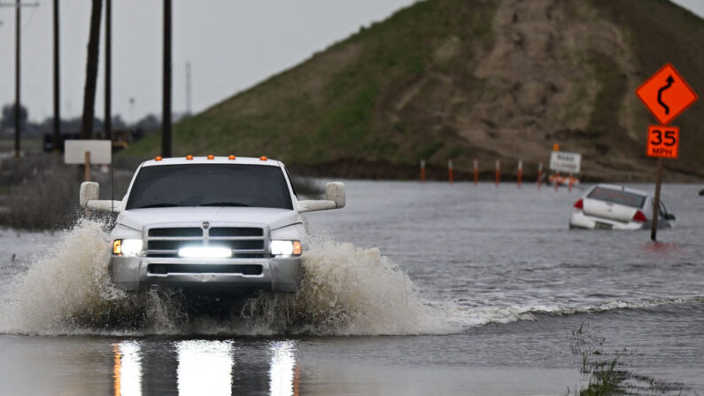 Una camioneta conduce en una carretera inundada fuera de Alpaugh en las inundaciones en el Valle Central durante una tormenta de invierno en el condado de Tulare cerca de Allensworth, California el 22 de marzo de 2023. (Patrick T. Fallon/AFP vía Getty Images)