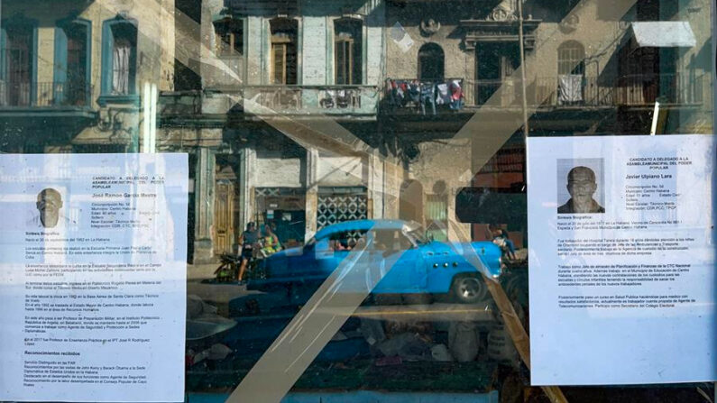 Fotografía de archivo, tomada el pasado 27 de noviembre, en la que se registró el reflejo de una calle de La Habana vieja, a través de una ventana que exhibe dos hojas de vida de delegados a diputados a la Asamblea del Poder Popular, en la capital de Cuba. EFE/Yander Zamora
