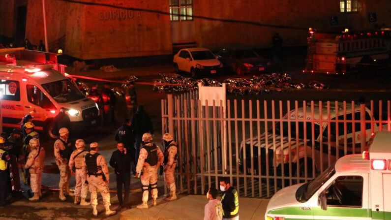 Bomberos y policías rescatan a migrantes de una estación migratoria en Ciudad Juárez, estado de Chihuahua (México), el 27 de marzo de 2023, donde al menos 40 personas murieron y decenas resultaron heridas tras un incendio en la estación migratoria. (Herika Martinez/AFP vía Getty Images)