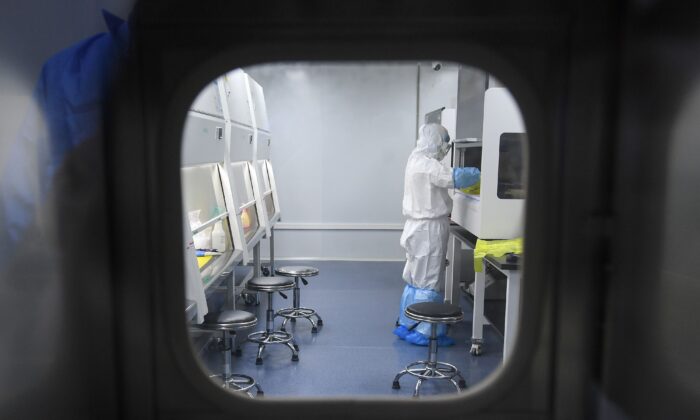 Un técnico del laboratorio trabaja con muestras de personas para analizarlas en busca del virus del PCCh, en el laboratorio "Fire Eye", en Wuhan, China, el 6 de febrero de 2020. (STR/AFP vía Getty Images)
