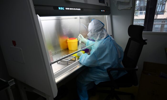 Un técnico procesa muestras en un laboratorio de la empresa biotecnológica china Coyote, antes de analizarlas en el Flash 20, una máquina desarrollada para análisis rápido del coronavirus COVID-19 en Beijing, el 27 de septiembre de 2020. (Greg Baker/AFP vía Getty Images)