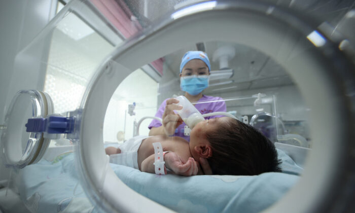 Una integrante del personal médico alimenta a un bebé en un hospital de Danzhai, en la provincia de Guizhou, suroeste de China, el 11 de mayo de 2021. (STR/AFP vía Getty Images)

