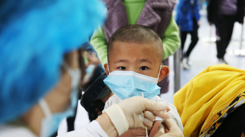 Un trabajador médico vacuna a un niño en un centro de vacunación temporal contra el COVID-19 en un estadio de fútbol en Chongqing, China, el 3 de noviembre de 2021. (Yang Min/Costfoto/Future Publishing vía Getty Images)