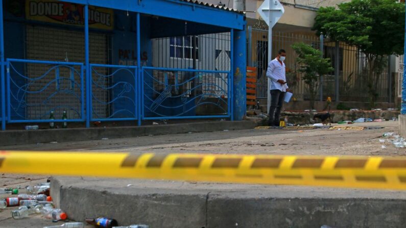 Un miembro de la policía científica colombiana inspecciona el exterior del bar donde seis personas fueron asesinadas por hombres armados en el barrio Las Flores de Barranquilla, el 12 de septiembre de 2022. (Jesus Rico/AFP vía Getty Images)