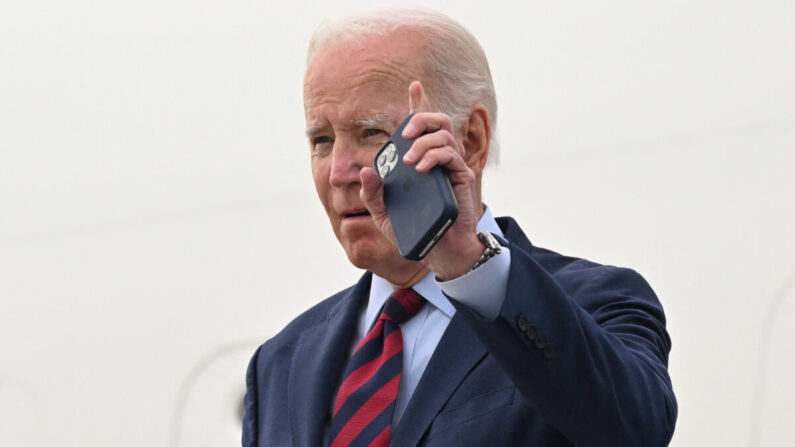 El presidente de Estados Unidos, Joe Biden, saluda con su teléfono en la mano mientras desembarca del Air Force One a su llegada al Aeropuerto Internacional de Los Ángeles en Los Ángeles, California, el 12 de octubre de 2022. (Saul Loeb/AFP vía Getty Images)