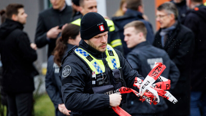 Un policía envuelve un cordón durante una visita del ministro del Interior alemán al tatort donde varias personas murieron en una iglesia en un tiroteo la noche anterior en Hamburgo, norte de Alemania, el 10 de marzo de 2023. (Axel Heimken/AFP vía Getty Images)