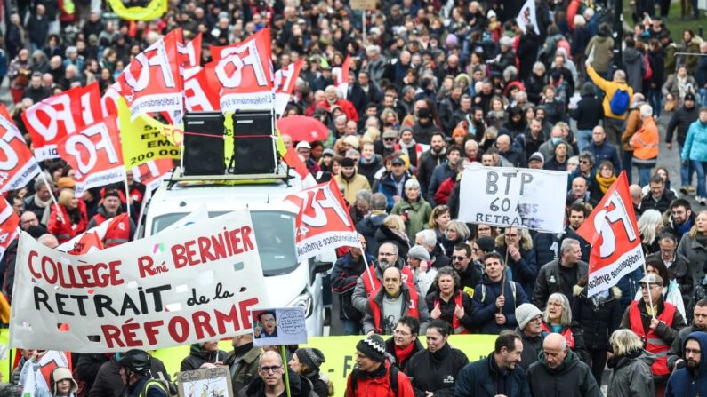 Manifestantes sostienen pancartas y banderas durante una manifestación en el marco de una jornada nacional de huelgas y protestas convocada por los sindicatos por la propuesta de revisión de las pensiones en Nantes, oeste de Francia, el 11 de marzo de 2023. (Sebastien Salom-Gomis/AFP vía Getty Images)