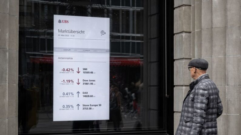 Un hombre observa un tablero de mercado en la sede del gigante bancario suizo UBS en Zúrich el 20 de marzo de 2023. (Fabrice Coffrini/AFP vía Getty Images)