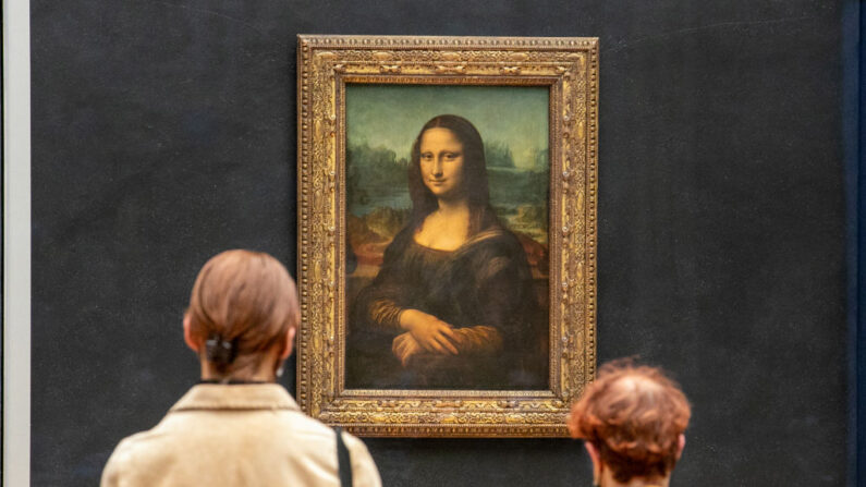 Los visitantes observan la pintura 'La Joconde' La Mona Lisa del artista italiano Leonardo Da Vinci en exhibición en una galería en el Louvre el 19 de mayo de 2021 en París, Francia. (Marc Piasecki/Getty Images)