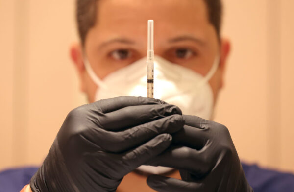 Un hombre llena jeringas con dosis de refuerzo de la vacuna contra COVID-19 en una clínica de vacunación contra la COVID-19 en San Rafael, California, el 6 de abril de 2022. (Justin Sullivan/Getty Images)