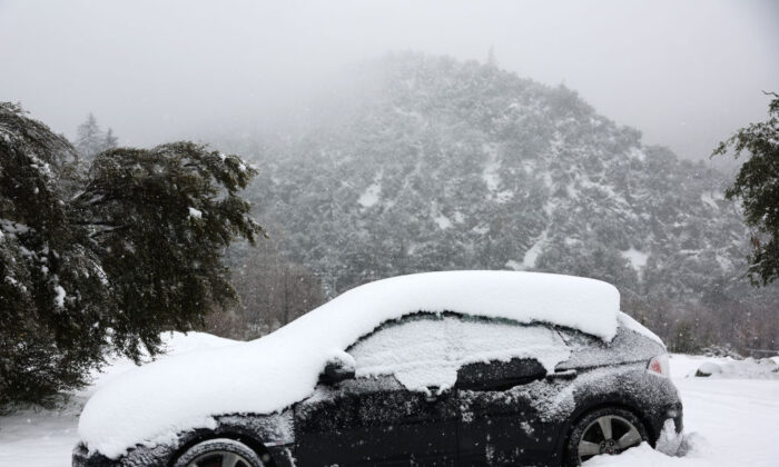Un vehículo está parcialmente cubierto de nieve, en las montañas de San Gabriel en el condado de San Bernardino, cerca del condado de Los Ángeles, en Mount Baldy, California, el 24 de febrero de 2023. (Mario Tama/Getty Images)