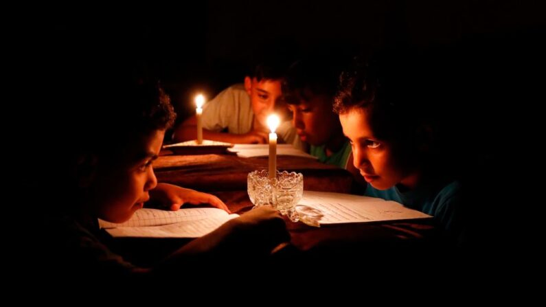 Una foto de archivo muestra a niños leyendo libros a la luz de las velas debido a la escasez de electricidad. (Thomas Coex/AFP vía Getty Images)