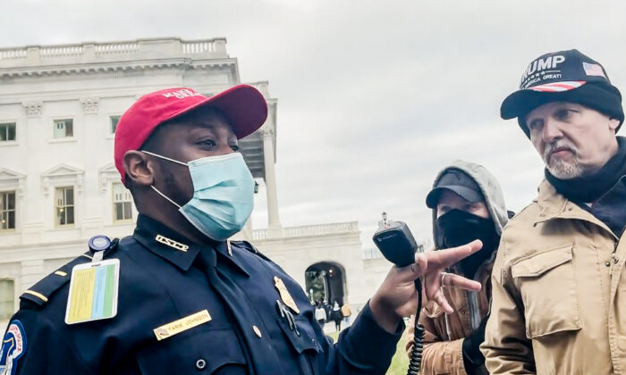 El teniente Tarik Johnson habla con un grupo de Oath Keepers sobre un grupo de oficiales atrapados en el Capitolio de EE. UU. en Washington, el 6 de enero de 2021. (Rico La Starza, Archive.org/Screenshot vía The Epoch Times)