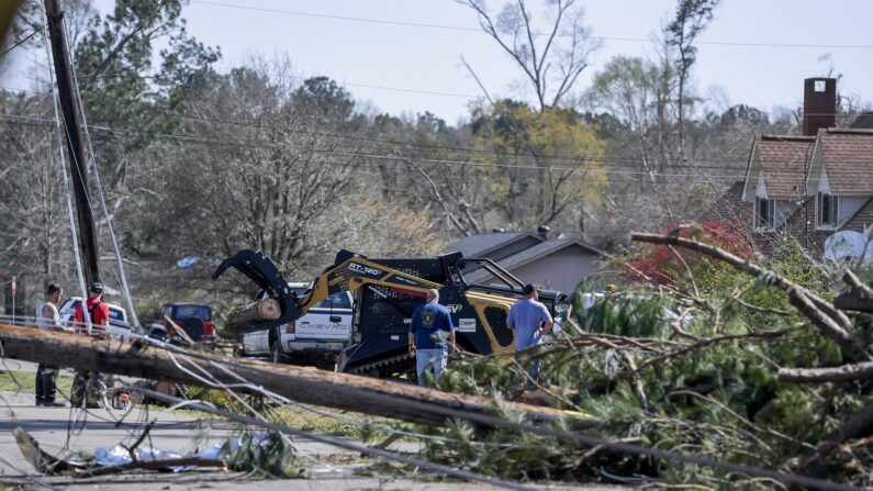 Residentes trabajan para retirar árboles caídos y líneas de servicios públicos de las calles de Amory, Mississippi, el 25 de marzo de 2023. (EFE/EPA/THOMAS GRANING)