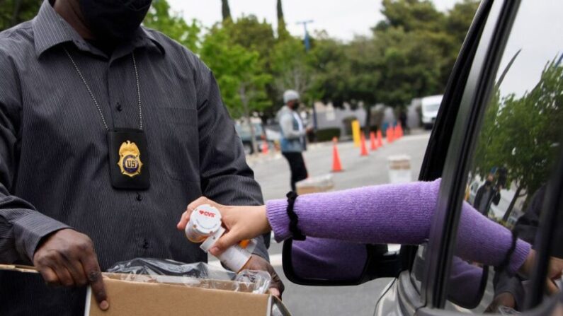 Un conductor entrega medicamentos a un funcionario de la Administración de Control de Drogas (DEA, por sus siglas en inglés) en una foto de archivo. (Patrick Fallon/AFP vía Getty Images)