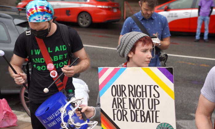 Miembros de un grupo de derechos de las personas transgénero protestan contra una manifestación de “Nuestros cuerpos, nuestros deportes” en Freedom Plaza, en Washington, D.C., el 23 de junio de 2022. (Terri Wu/The Epoch Times)
