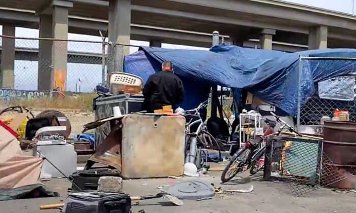 Una persona frente a un campamento de personas sin hogar bajo la I-880 en Oakland, California, el 26 de mayo de 2022. (Cynthia Cai/NTD Television)