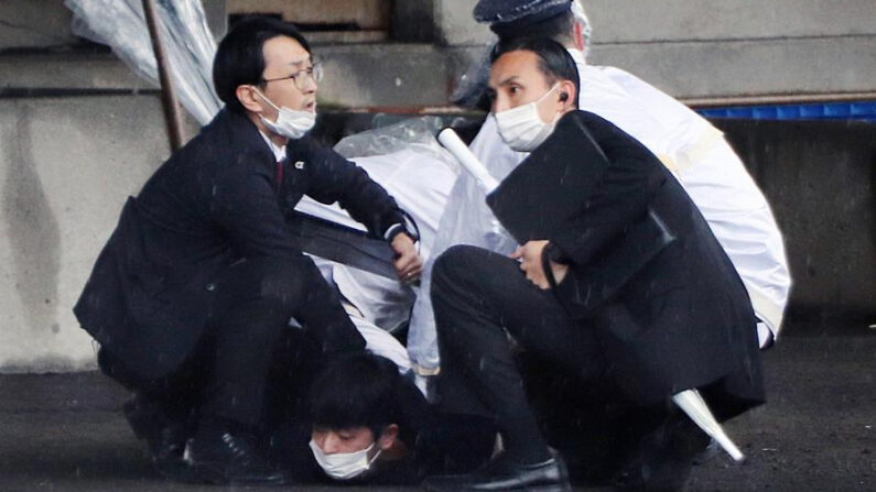 Agentes de policía arrestan a un hombre sospechoso de haber arrojado explosivos cuando el primer ministro japonés, Fumio Kishida, estaba a punto de pronunciar este sábado 15 de abril de 2023 un discurso en un puerto pesquero en Wakayama, oeste de Japón. EFE/EPA/Jiji Press Japan