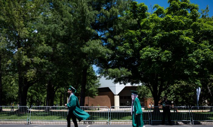 Los graduados suben al escenario durante una ceremonia de graduación en la Universidad George Mason en Fairfax, Virginia, el 13 de mayo de 2021. (Andrew Caballero-Reynolds/AFP vía Getty Images)